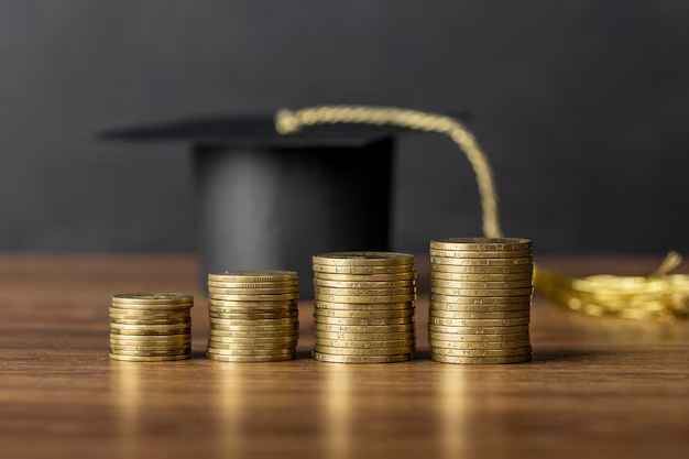 graduation robe hat and gold coins kept side by side