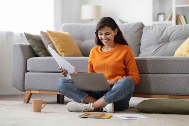A happy female student is holding a passport that has air tickets slid inside