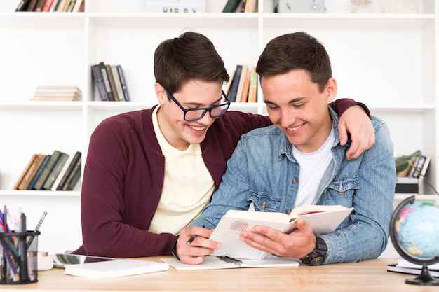 2 students reading a book in excitement